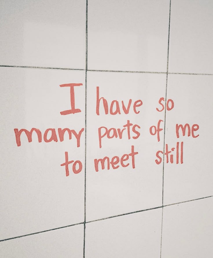Red text on white tiles reads: "I have so many parts of me to meet still." The casual, uneven handwriting hints at personal growth and the journey of still becoming. Some words appear larger, reflecting moments of self-doubt and discovery.